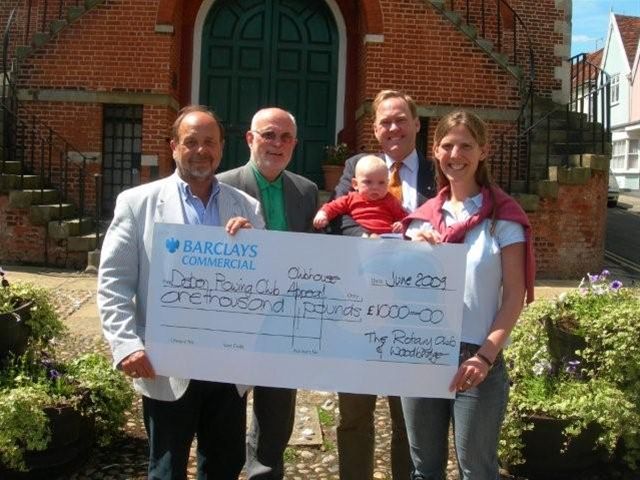President Geoff Springett and David Houchell of Woodbridge Rotary Cub are seen here presenting a cheque for £1000 to Nicola and William Notcutt who are receiving it on behalf of the Deben Rowing Club.  

