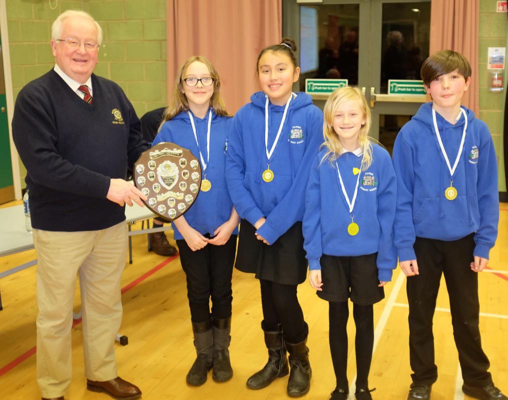 Club President Colin Mackenzie presents the 2019 trophy to the team from Dairsie Primary School