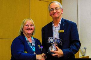 Oswestry President Ian Haigh receives the Best Website Trophy from District Governor Molly Youd.