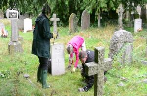 Rotarians tidying the War Graves in Black Bourton Churchyard (Photo courtesy Witney TV)