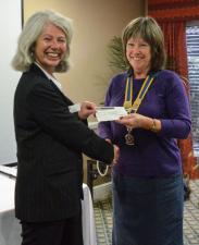 Linda Whitby receives a cheque from President Kath with funds raised at the Newbury Rotary Charity Golf day in May