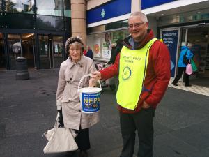 Mrs Dorothy Jacobi of Dundee making a donation to Rotarian Bob Black.