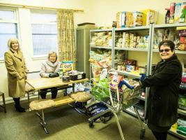 With the donations delivered to the Food Angels,  Betty and Elma lend a helping hand to  Rev. Branwen to restock the shelves.