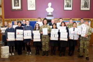 Interactors (Junior Rotarians) from Queen Victoria School in uniforms of the three armed services in the cadet force, together with civilian members, carrying their collection of shoeboxes