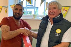 Kawa Ghaze accepts a TV from Oswestry Rotary Club's Mike Griffiths.