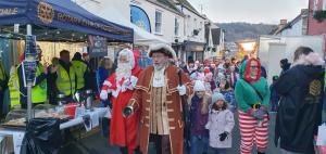 Santa and crier pass the Tyndale Rotary stall