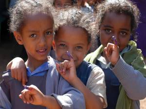 Young children proudly show their 'purple pinkies', received after immunisation against polio