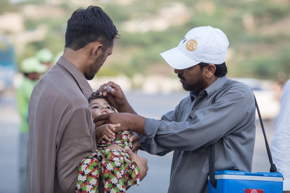Rotary member in Pakistan delivering polio vaccination