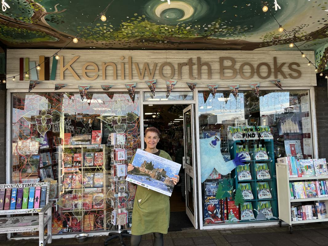 Judy of proudly displays her 2025 Advent Calendar in front of her shop