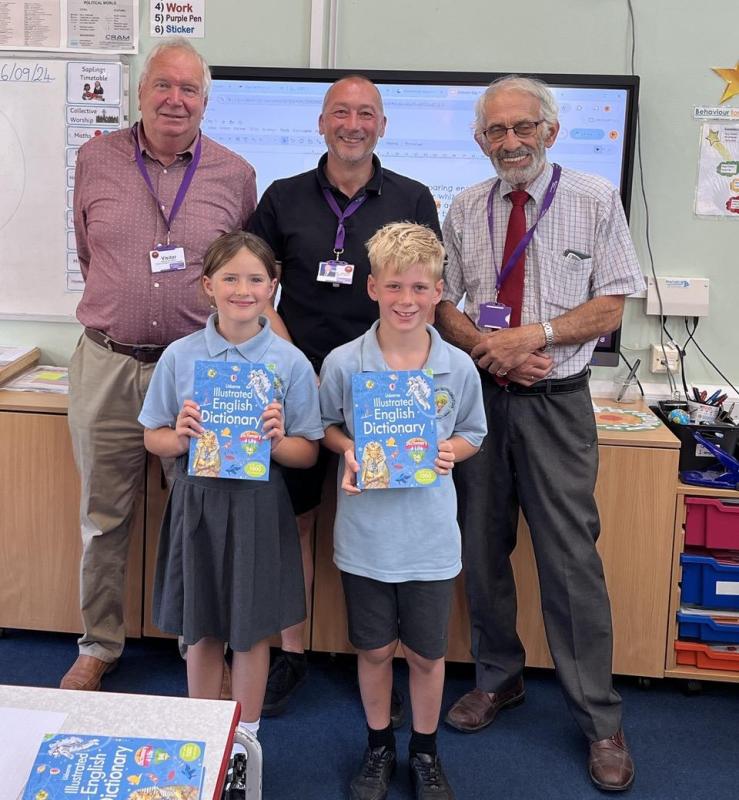 Students with their dictionary 4 Life and a Rotarian