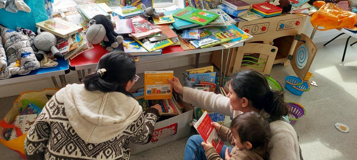 Keen youngsters and parents looking at Rotary Cambridge South donated books to take home at Arbury Social Centre