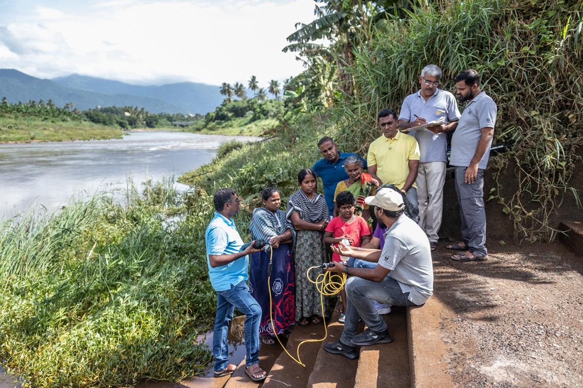 ESRAG members speaking with community members during a river clean-up exercise in South India.