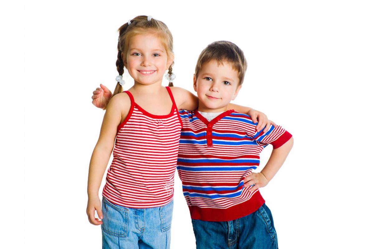 Very young sister and brother with their arms round each other's waist.