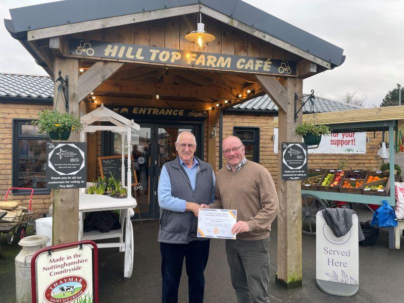 Past President Ken Eggleston presents a letter of thanks and certificate of appreciation to John Rule, manager of Hilltop restaurant for their help with our collection this Christmas.