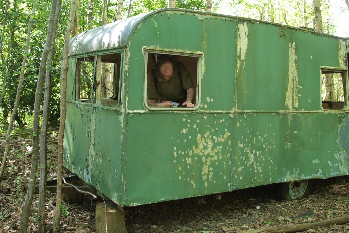 A derelict caravan in a wood.