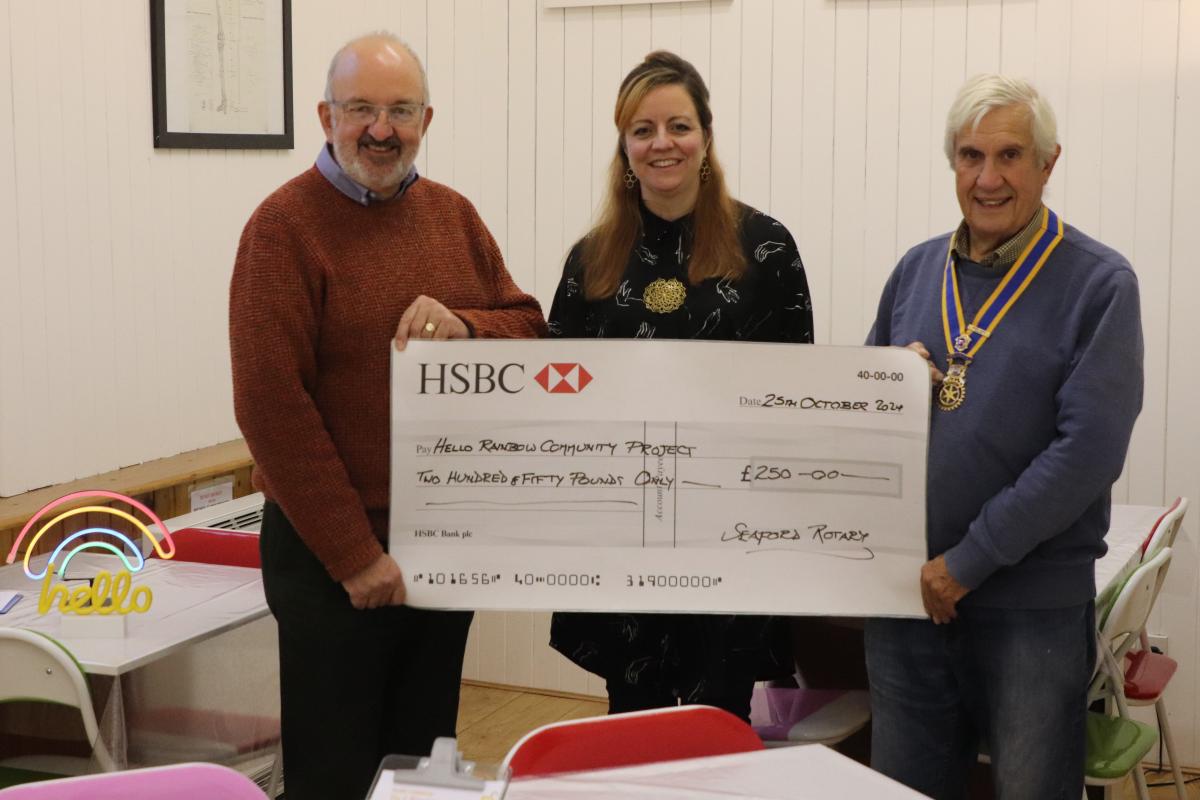 President Clive Livingstone with Community Service Chair Rodney Reed presenting the cheque to Claire Diola from the Hello Rainbow Community Project