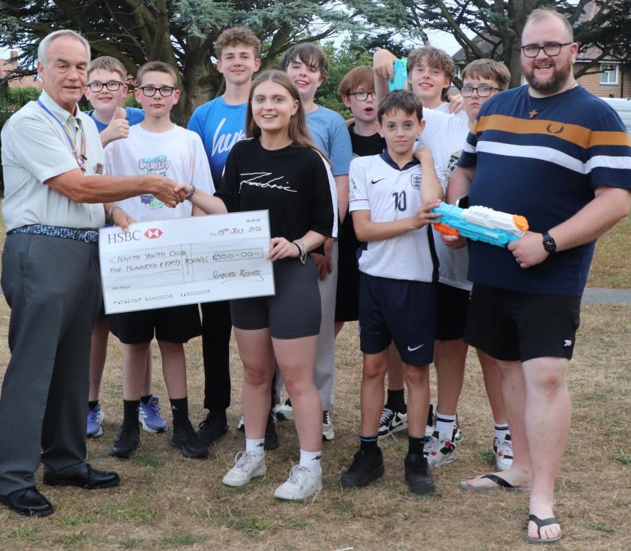 President Mike presenting the donation to Lillia watched by Stefan Bracher, the Children, Youth and Family Missioner and other members of the youth club