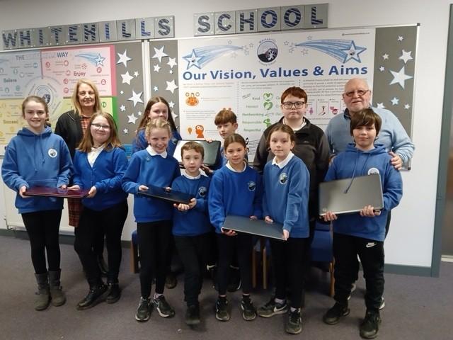 Rotarian Jim McCluskey handing over  five laptops to Whitehills Digital Leaders class