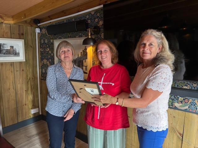 Caroline Whelan, daughter of David Mitchell, [right] presenting the award to Diana Dove [left] and Nikki Pitt [centre] representing the Lighthouse organising committee.