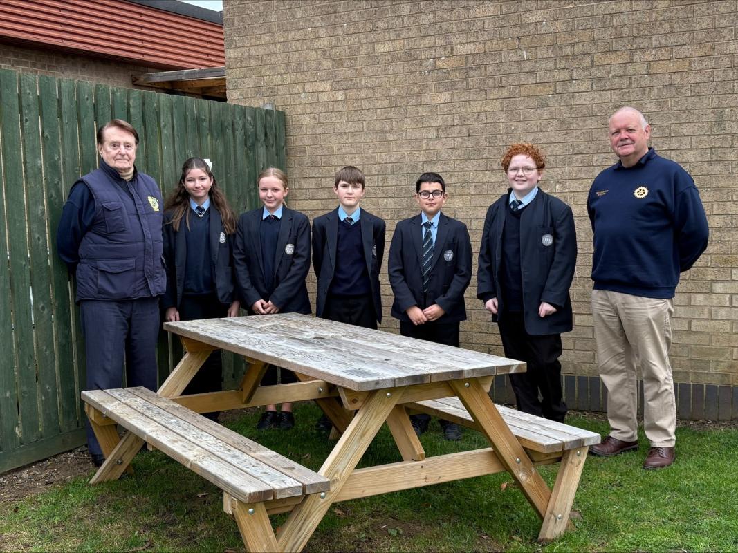 Rotarians John Garley and Geoff Banks pose with pupils from The Ferrers School and the newly donated bench.