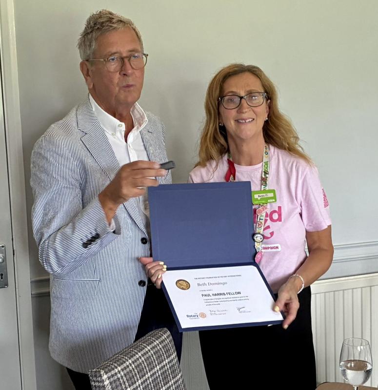 Jpint President Mark Hurley presents Beth Domingo with a Paul Harris Fellowship
