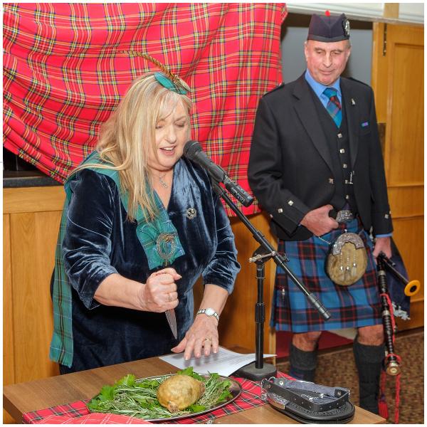 June Fowler stabbing the Haggis, watched by bagpiper Cameron Weatherburn, at last year's Comedy Burns Supper.