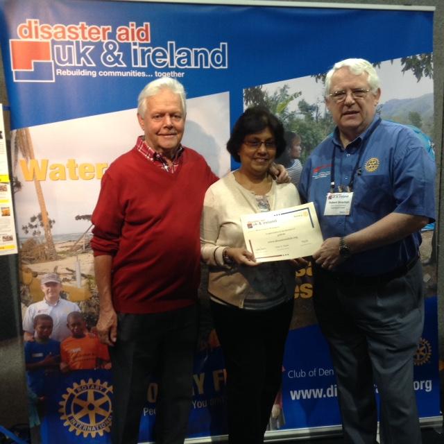 Robert Strachan, Chairman of Disaster Aid UK and Ireland presents a certificate of appreciation to Patricia and Alan Hoggarth for our club's £400 donation.