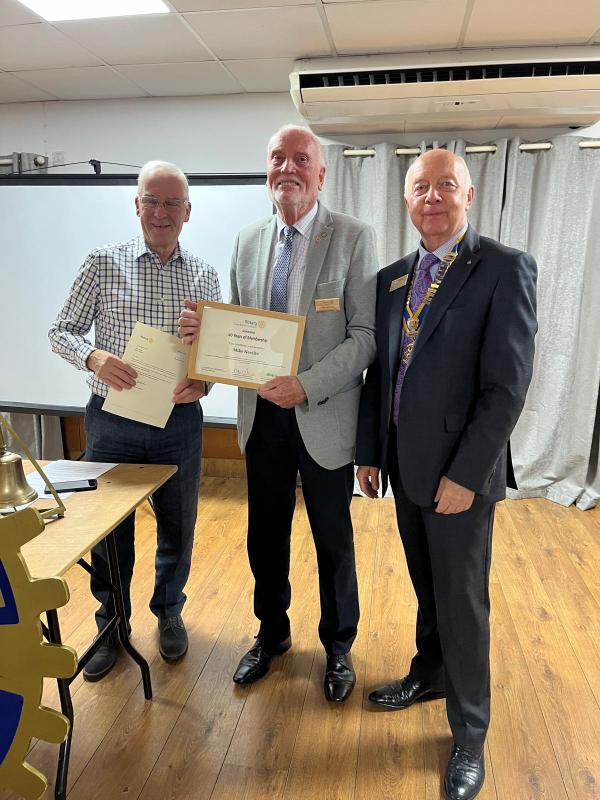 Mike poses with Anton and Robin for a picture showing his certificate and commendation letter.