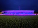 The grandstand at Mansfield Park illuminated in purple for World Polio Day