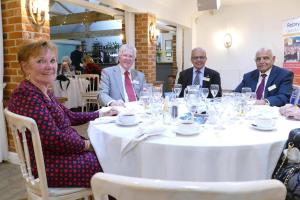 Group of people round a circular dining table.