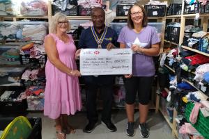 President Collins Griffith presenting the grant to Helen and Dawn (wearing the pink dress) from Seahaven Baby Bank