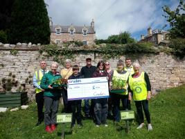 Cruden Homes hand over a cheque for creating a community garden