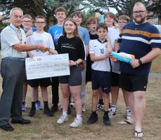 President Mike presenting the donation to Lillia watched by Stefan Bracher, the Children, Youth and Family Missioner and other members of the youth club