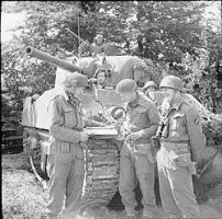 Major W Holtby, commanding 'C' Squadron, East Riding Yeomanry, 27th Armoured Brigade, briefs troop commanders in front of his HQ Sherman tank, 28 June 1944.