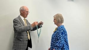District Governor Annette receiving chain of office from outgoing DG
