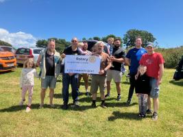 The Dads Network holding the cheque, with some of the dads and their children on their summer camp which the grant helped fund.