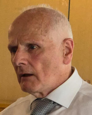 A bald man wearing a white shirt and grey tie