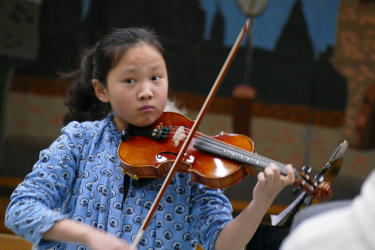 A young chinese girl playing the violin