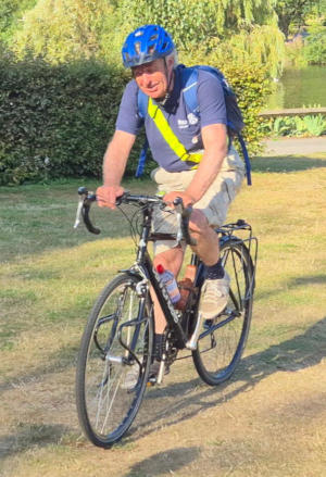 A man on a bike wearing a crash helmet