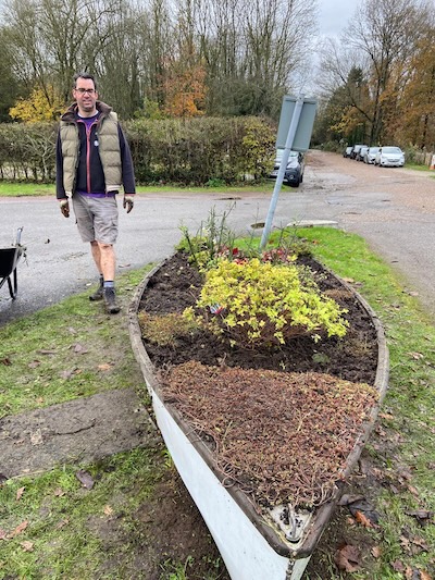 Man standing beside planted up boat